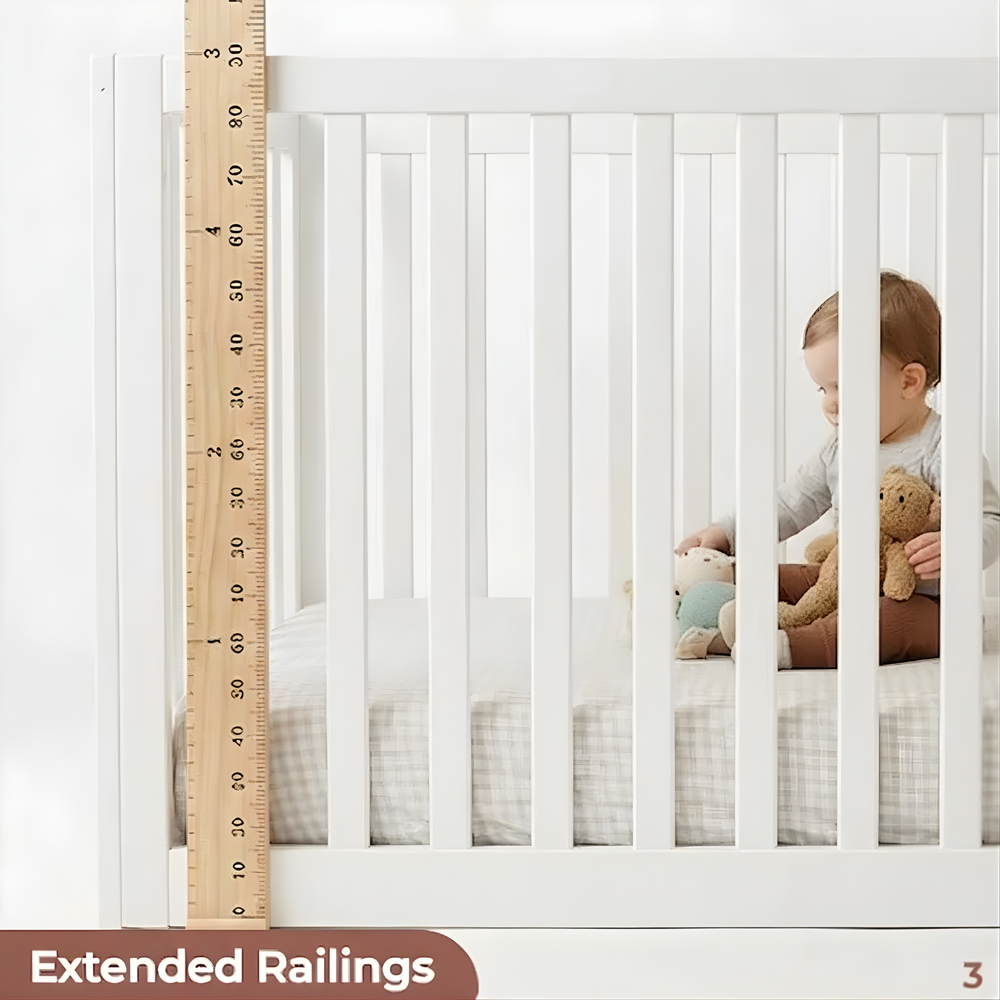Child in a crib with extended railings and a wooden ruler for scale.