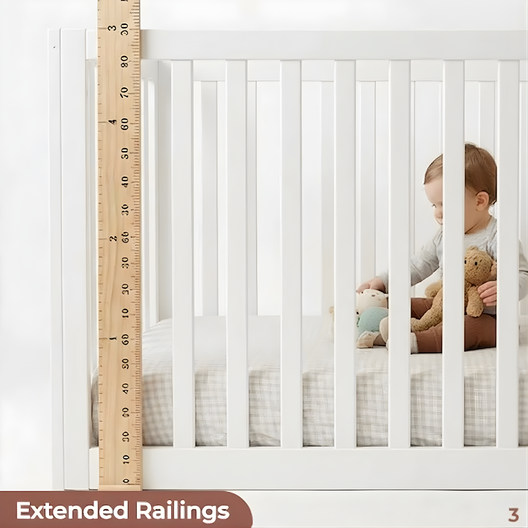 Child in a crib with extended railings and a wooden ruler for scale.