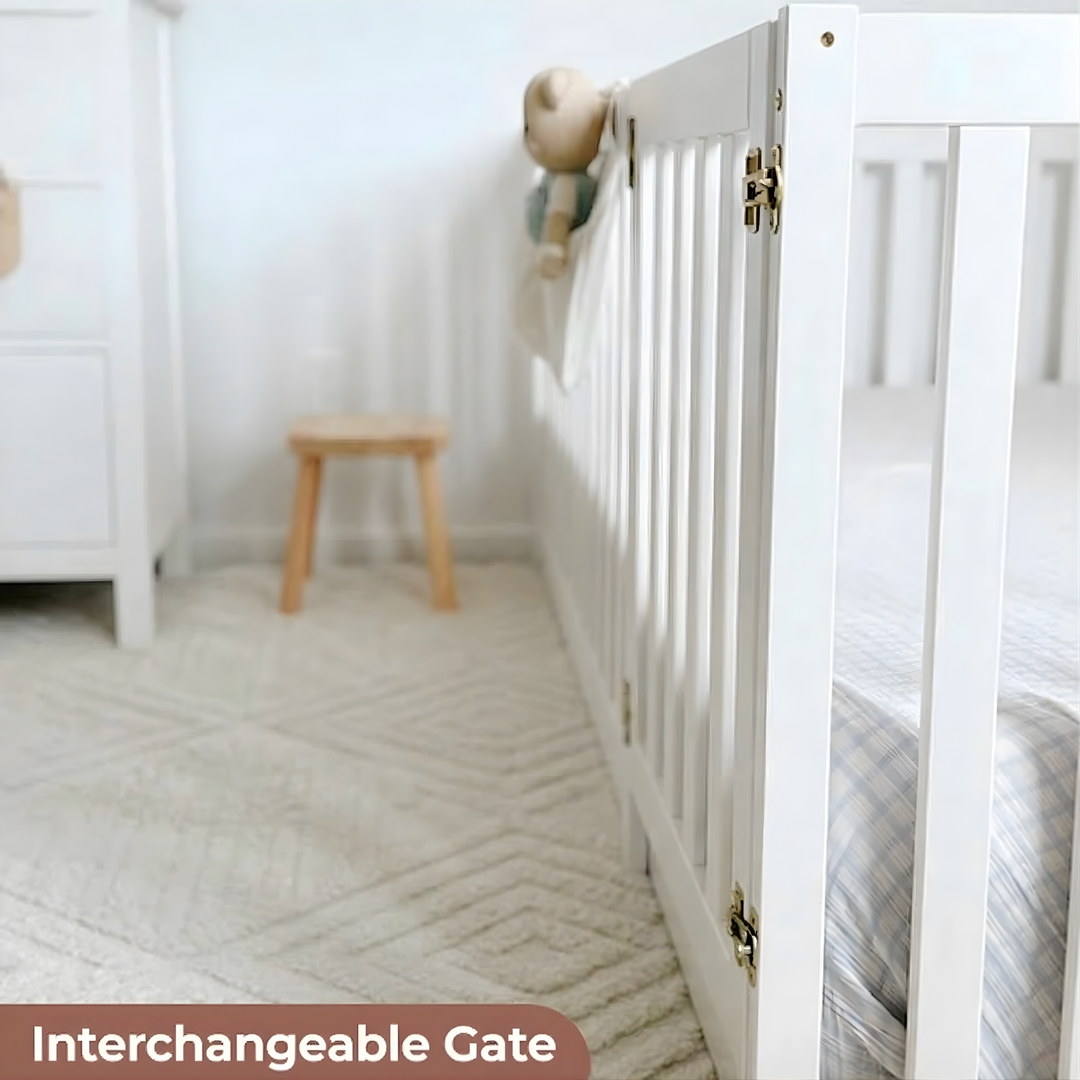 White crib with interchangeable gate in a nursery setting