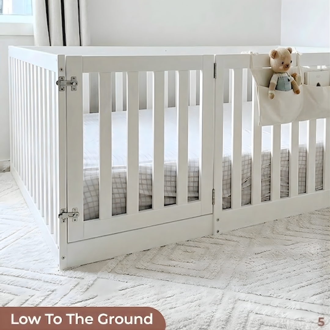 White crib with a teddy bear in a room with light-colored carpet and curtains.