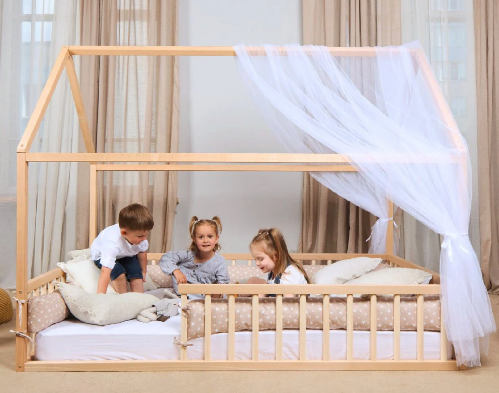 Three kids playing on a montessori floor bed