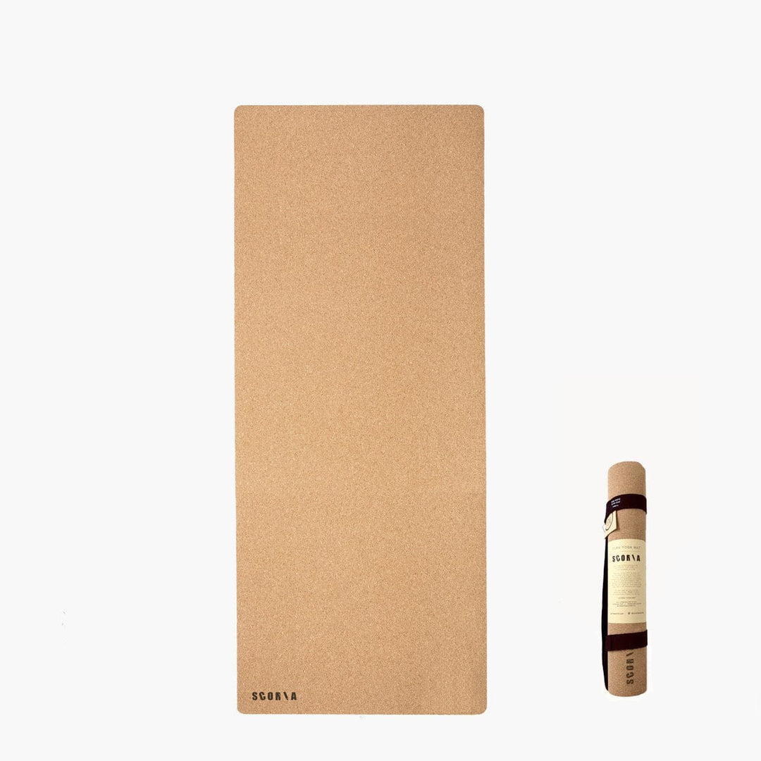 A large rectangular kid yoga mat stands vertically against a white background, with a small bottle displayed on a white pedestal to the right. 
